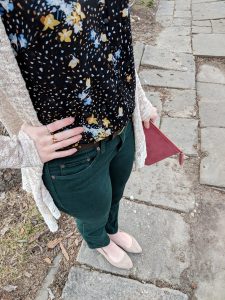 black floral Cabi tank top and green jeans