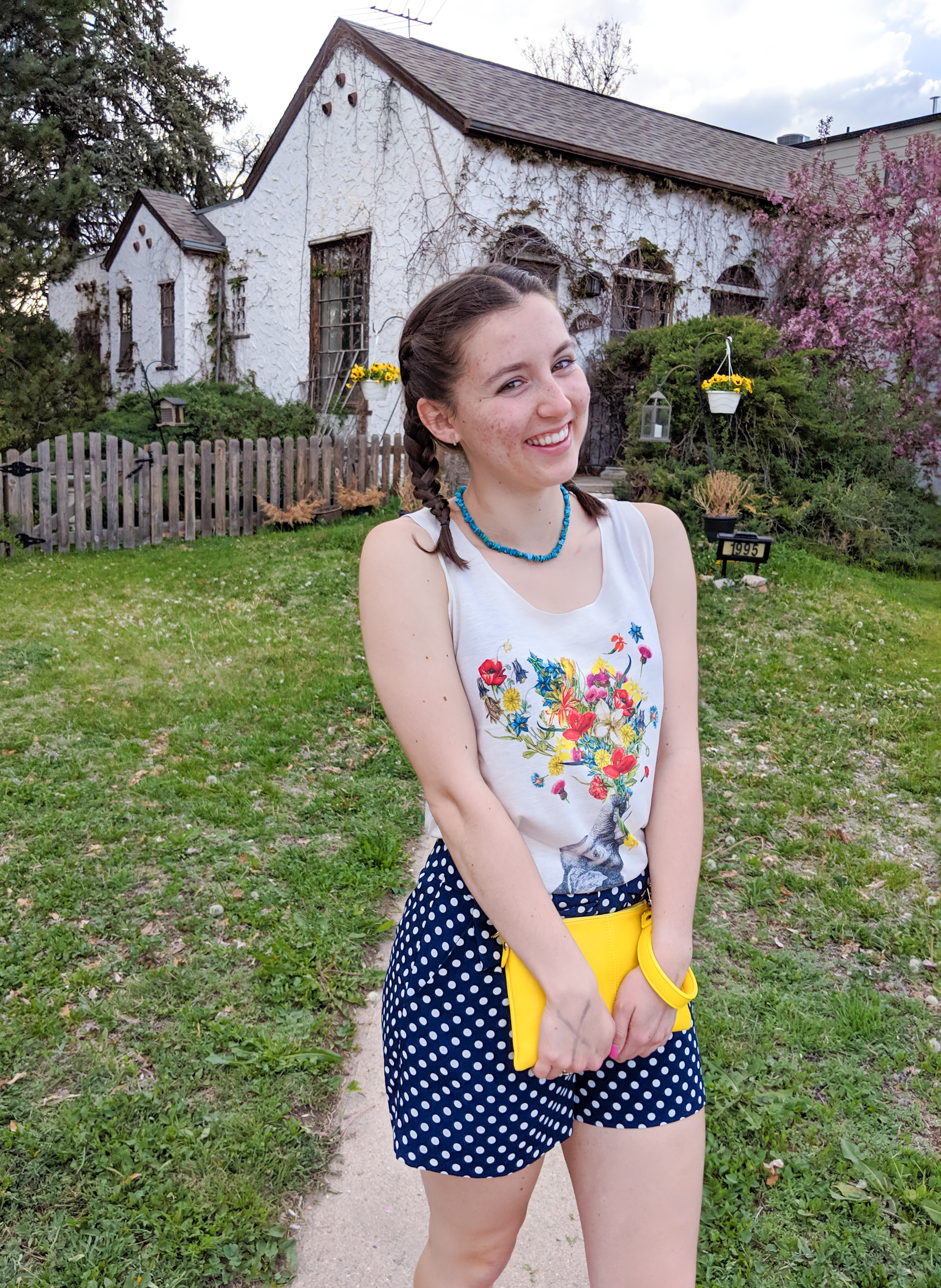 floral graphic tank top, yellow clutch, polka dot shorts, French braids