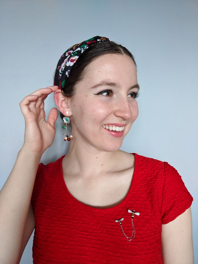 red blouse, bee pins, floral headband, statement earrings