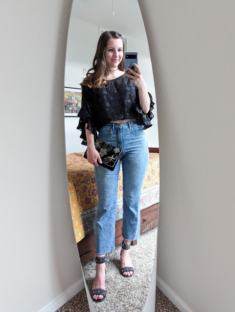 black-statement-blouse-cropped-flared-jeans-black-heels-beaded-clutch